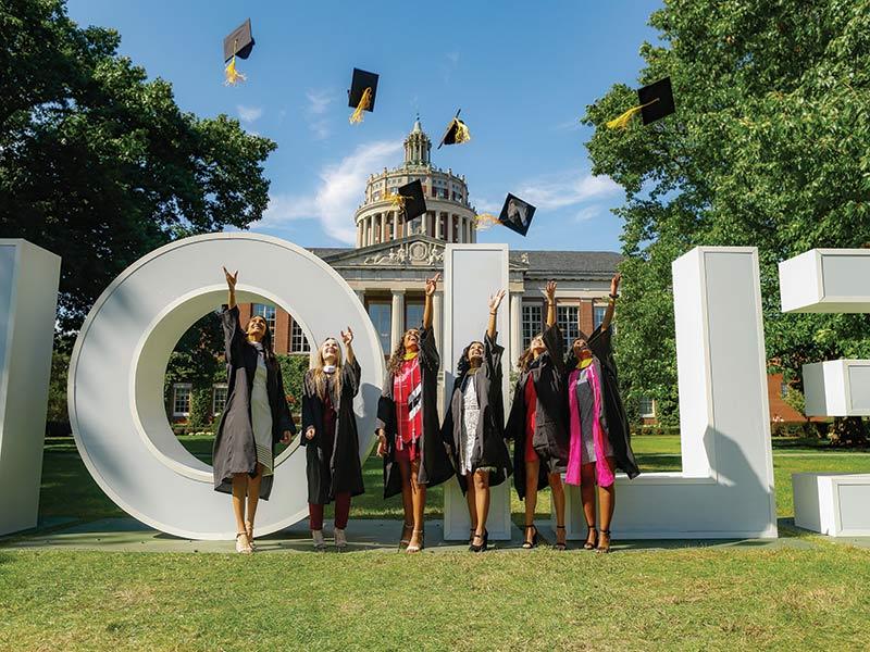 image of 2021 graduates celebrating by meliora letters on eastman quad rochester